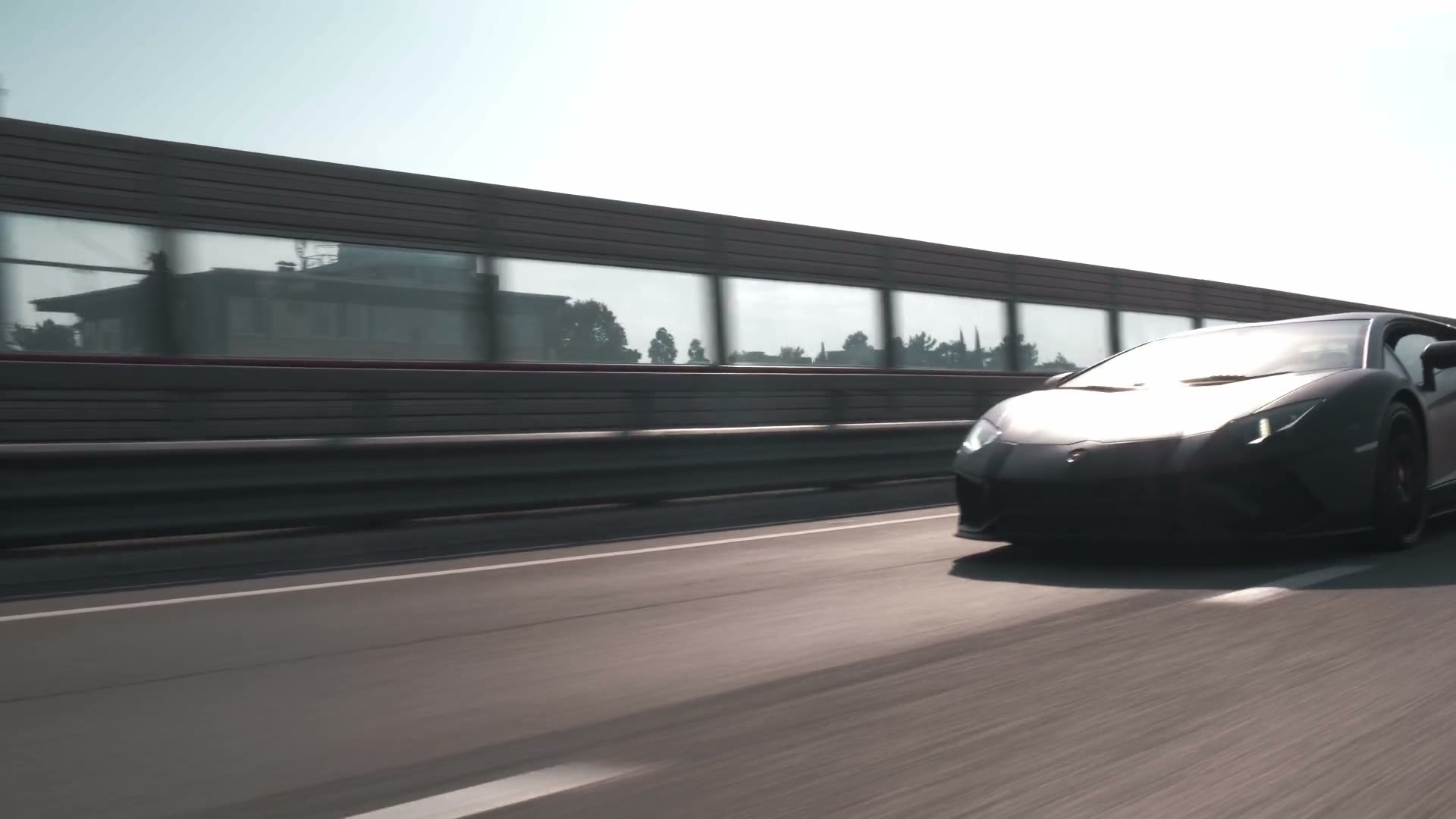 Black Lamborghini driving on a city highway